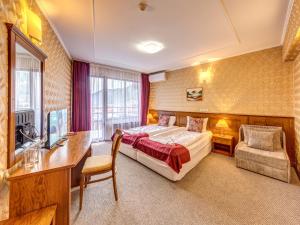 a hotel room with a bed and a desk and a television at Хотел Елит Релакс in Devin +36 photos