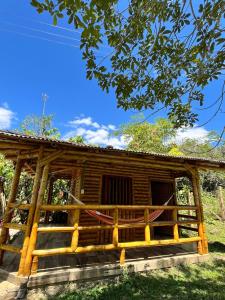 a log cabin with a blue sky in the background at Cabañas Aires de mi campo in Paicol