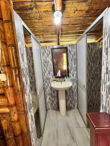 a bathroom with a sink and a mirror at Cabañas Aires de mi campo in Paicol