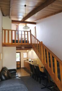 a room with a staircase and a table and chairs at Forest Trail Lodge in Hanmer Springs