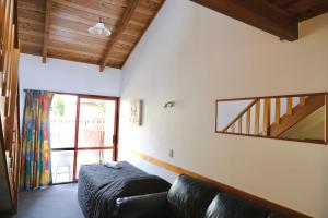 a living room with a couch and a window at Forest Trail Lodge in Hanmer Springs