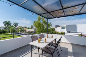 a patio with a table and chairs on a balcony at iKAL 93 Casa Nido de Mar 9 Persons Occupancy, Pool, 7 Beds in Nuevo Vallarta