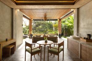a dining room with a table and chairs at Beehouse Dijiwa Ubud in Ubud
