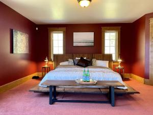 a bedroom with a bed with red walls and a table at Cajun Cabin Private Nature Resort in Minden