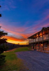 a building with a sunset in the background at Cajun Cabin Private Nature Resort in Minden