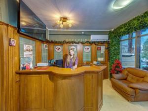 a woman sitting at a bar in a room at Хотел Елит Релакс in Devin