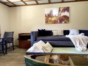 a living room with a blue couch and a table at Cajun Cabin Private Nature Resort in Minden