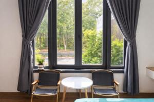 two chairs and a table in front of a window at Khôi Đại Hotel - gần sân bay Buôn Ma Thuột, near Buon Ma Thuot Airport in Buon Ma Thuot