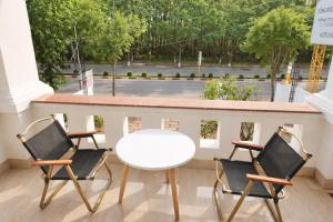 a white table and two chairs on a balcony at Khôi Đại Hotel - gần sân bay Buôn Ma Thuột, near Buon Ma Thuot Airport in Buon Ma Thuot