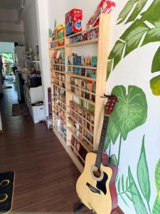 a guitar is leaning against a wall in a store at Happiness Hostel in Phra Ae beach