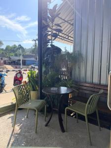 a patio with a table and two chairs and a window at Happiness Hostel in Phra Ae beach