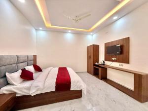 a bedroom with a bed and a desk and a tv at Hotel Betwa sarowar in Orchha