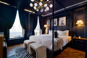 ein Schlafzimmer mit Himmelbett und Kronleuchter in der Unterkunft The Highliner Hotel in Gloucester