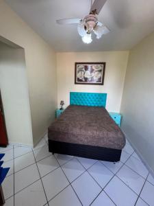 a bedroom with a bed and a ceiling fan at Apto Verde Água in Mongaguá