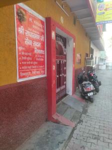 a motorcycle parked outside of a building with a red door at Shri Radha Raman Ji Seva Sadan in Mathura