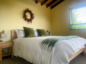 a bedroom with a bed with a wreath on the wall at TekapoB2 Lakeview Apartment in Lake Tekapo