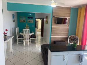a kitchen and living room with a table and chairs at Apto Verde Água in Mongaguá