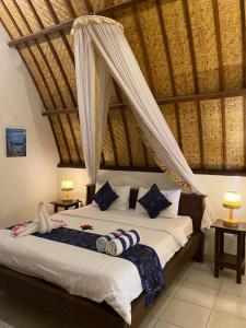 a bedroom with a large bed with a canopy at Follow The Rabbit Bungalow in Gili Islands