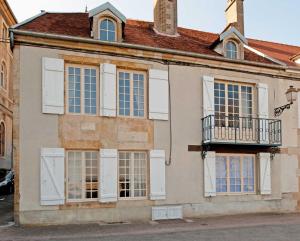an old building with white windows and a balcony at Le balcon de la crémaillère in Langres