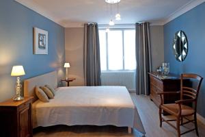 a bedroom with a bed and a desk and a window at Le balcon de la crémaillère in Langres