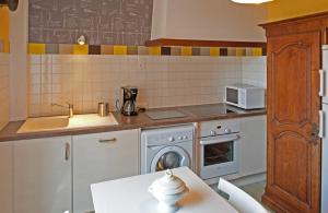 a kitchen with a sink and a washing machine at Le balcon de la crémaillère in Langres