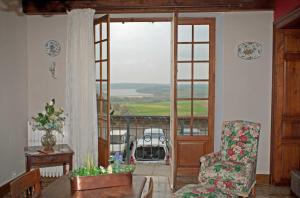 a living room with a door open to a balcony at Le balcon de la crémaillère in Langres +12 photos