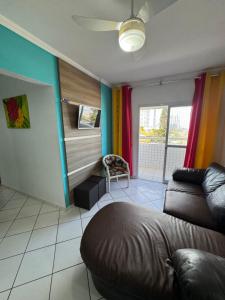 a living room with a couch and colorful curtains at Apto Verde Água in Mongaguá