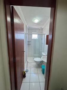 a bathroom with a toilet and a sink at Apto Verde Água in Mongaguá +13 photos