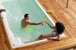 a man and a woman sitting in a bath tub at Casa Barú in Barú