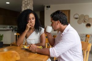 a man and woman sitting at a table with a cup of coffee at Casa Barú in Barú