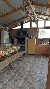 a large kitchen with a bench and a stove at Loft in El Tabo +3 photos