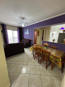 a living room with a table and a couch at Apto Lilas in Mongaguá +16 photos