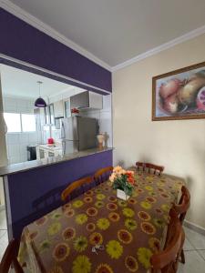 a dining room table with flowers on top of it at Apto Lilas in Mongaguá