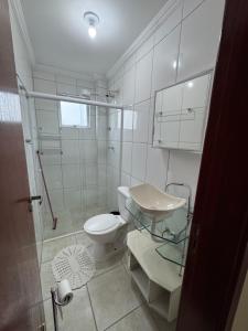 a bathroom with a toilet and a sink and a shower at Apto Lilas in Mongaguá