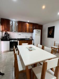a kitchen with a white table and chairs and a white refrigerator at Cunumí in Puerto Iguazú