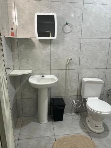 a bathroom with a toilet and a sink and a tv at Pousada e Cachoeira Paraiso in Barra do Garças