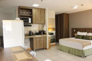 a small hotel room with a bed and a kitchen at ApartHotel - Nobile Suites Monumental Brasília in Brasília