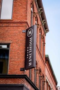 ein Schild an der Seite eines Backsteingebäudes in der Unterkunft The Highliner Hotel in Gloucester
