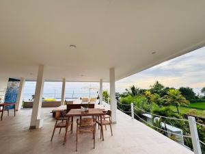 a dining room with a table and chairs on a balcony at Trika Surfcamp Bali in Airsatang +44 photos