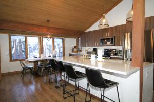 a kitchen with a bar with chairs and a counter top at Mountainback 116 LoftCorner in Mammoth Lakes