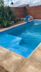 a blue swimming pool with a water fountain at Cunumí in Puerto Iguazú +1 photo