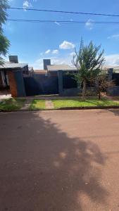 a house with a tree on the side of a street at Cunumí in Puerto Iguazú