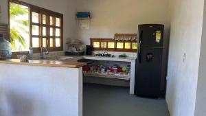 a kitchen with a black refrigerator and a counter at Mi refugio in Moñitos