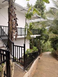 a house with a black fence and a walkway at Liora Cottage Ella in Ella