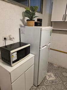 a microwave sitting on top of a white refrigerator at Departamento dos dormitorios en 3er piso por escaleras in Chajarí