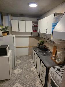 a kitchen with white cabinets and a white refrigerator at Departamento dos dormitorios en 3er piso por escaleras in Chajarí
