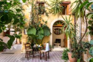 an outdoor patio with a table and chairs and plants at Ifigenia Traditional Rooms & Maisonettes in Chania
