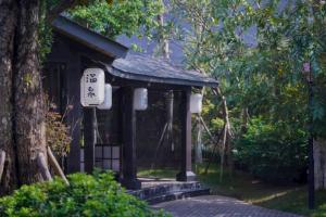 a small shrine with a sign in front of a tree at Wyndham thanh thủy in La Phu