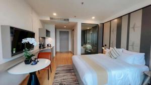 a bedroom with a bed and a table and a television at Wyndham thanh thủy in La Phu