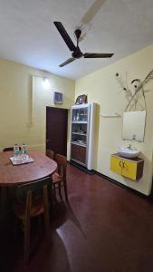 a dining room with a table and a ceiling fan at Oudh blooms in Shoranūr
